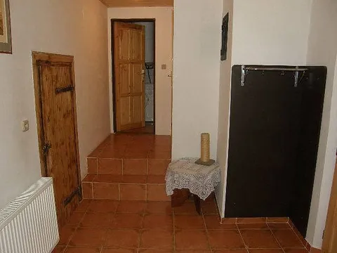 Vstupní chodba s dlažbou, schody a dřevěnými dveřmi